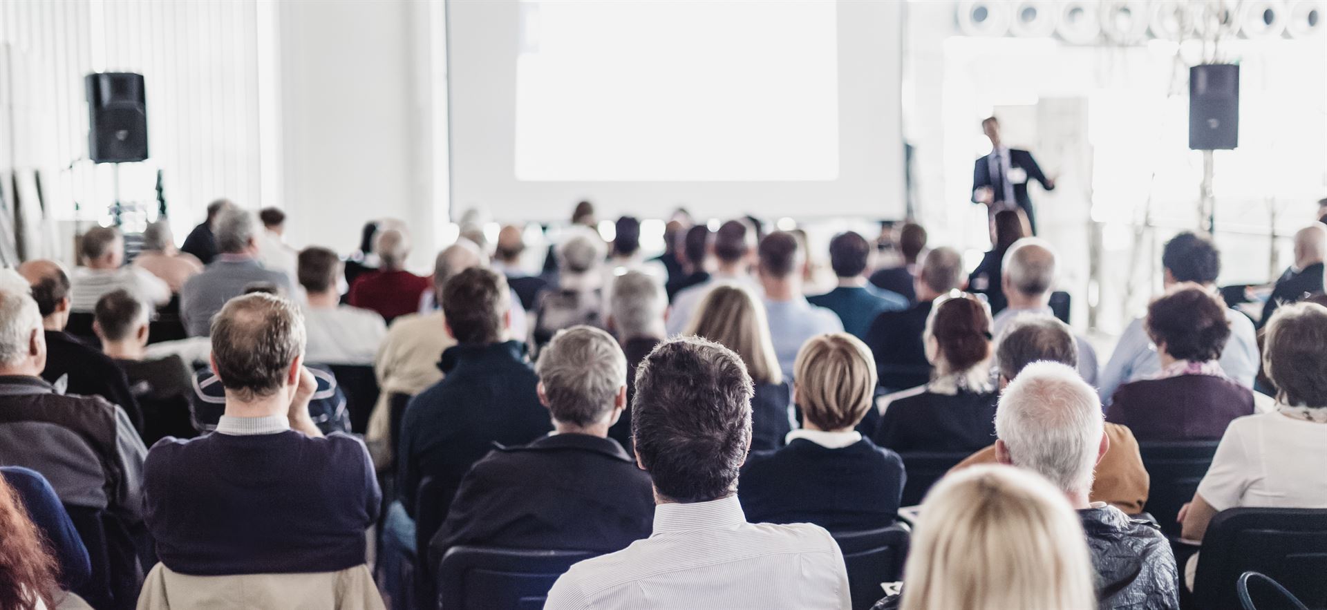 Speaker Giving a Talk at Business Meeting. Audience in the conference hall. Business and Entrepreneurship. Panoramic composition suitable for banners.